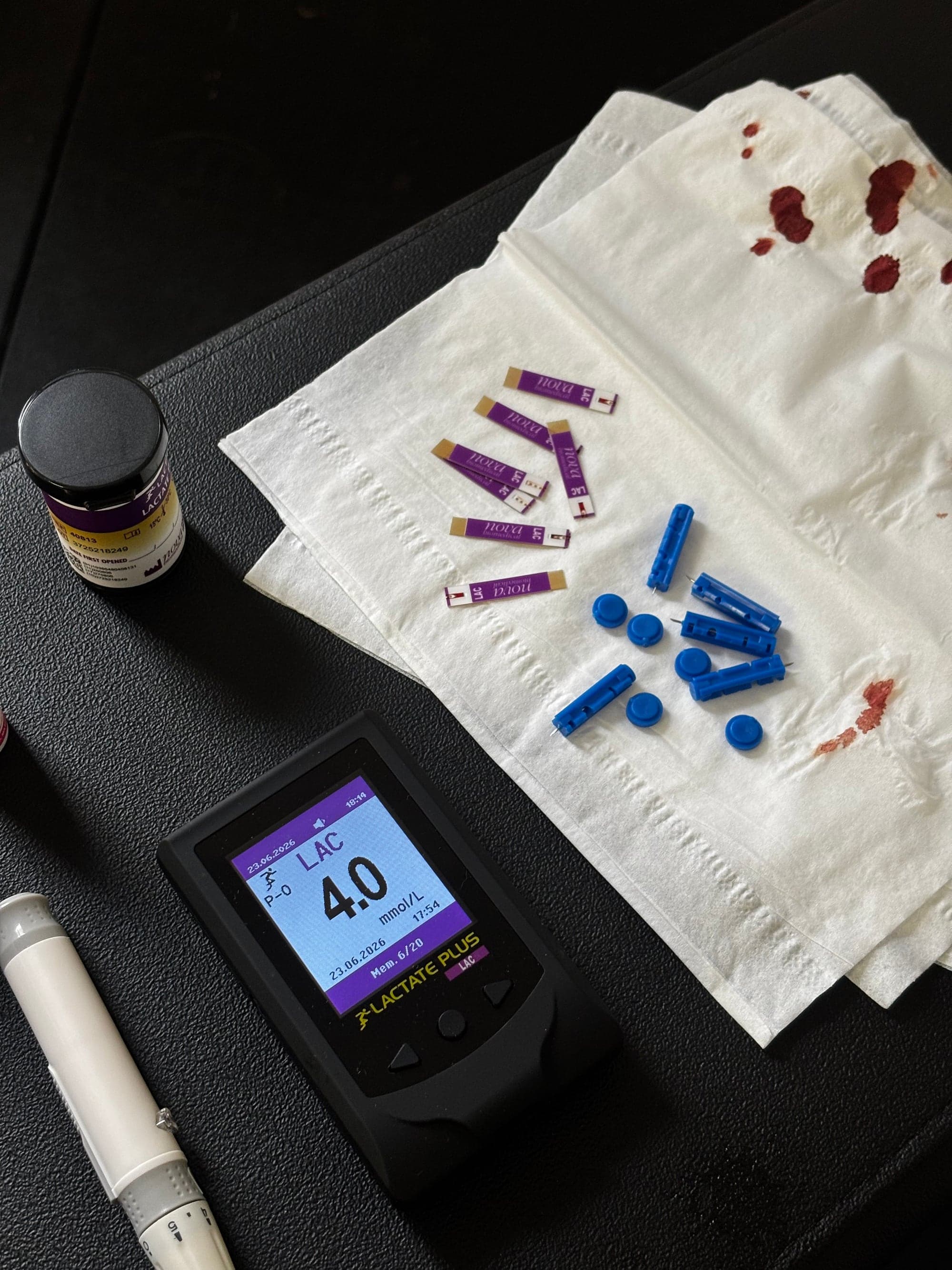 Lecteur de lactate affichant 4.0 mmol/L, bandelettes et autopiqueurs après un test